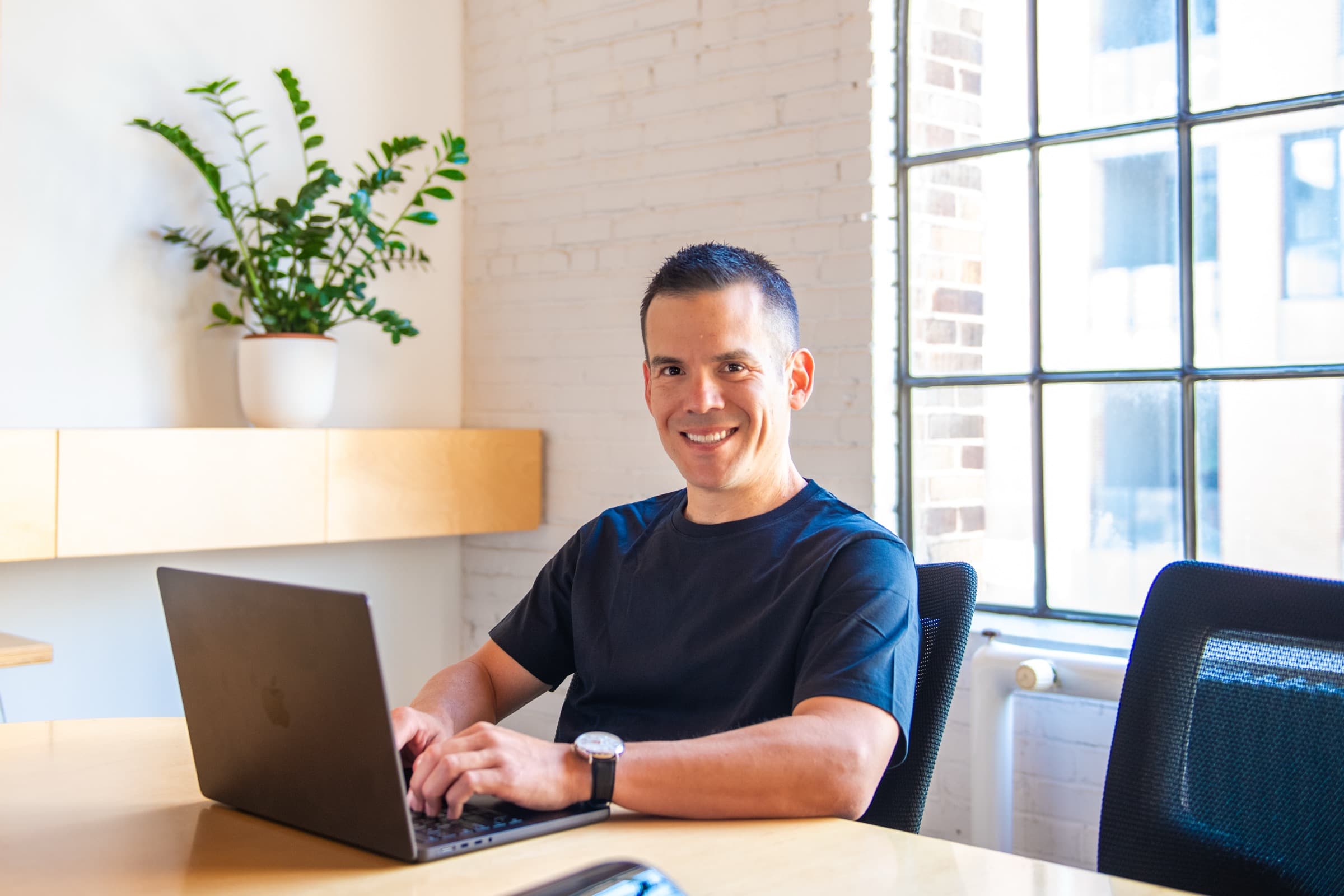 Mauricio working at a laptop in a bright office
